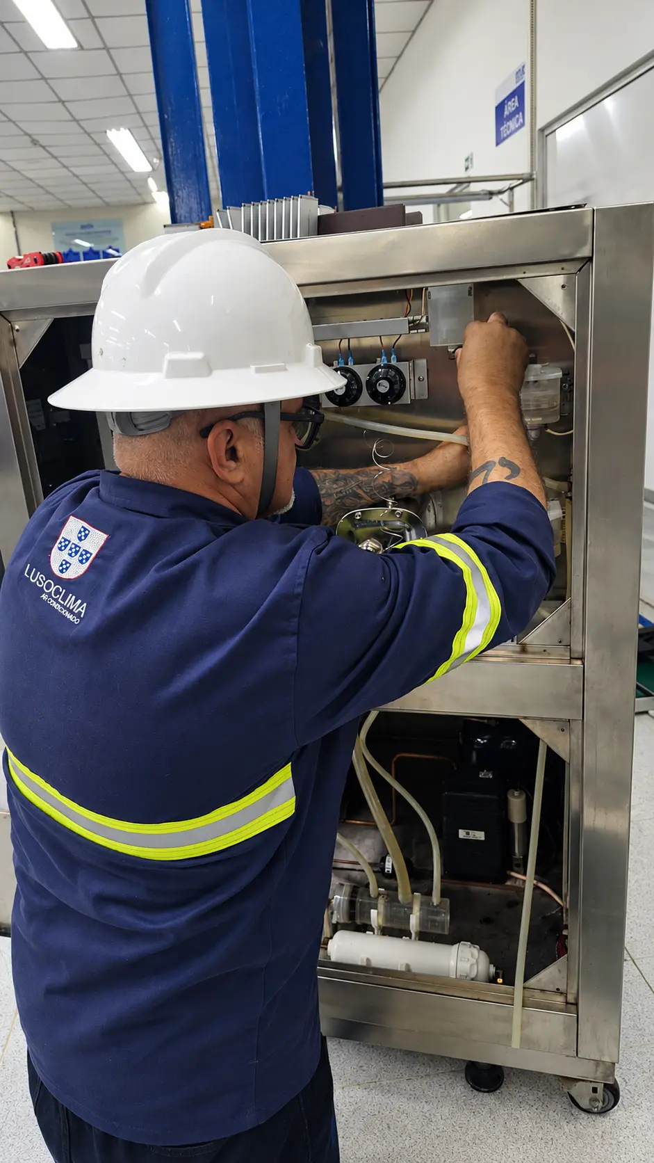 Profissional com EPI completo executando serviço em equipamento de área técnica