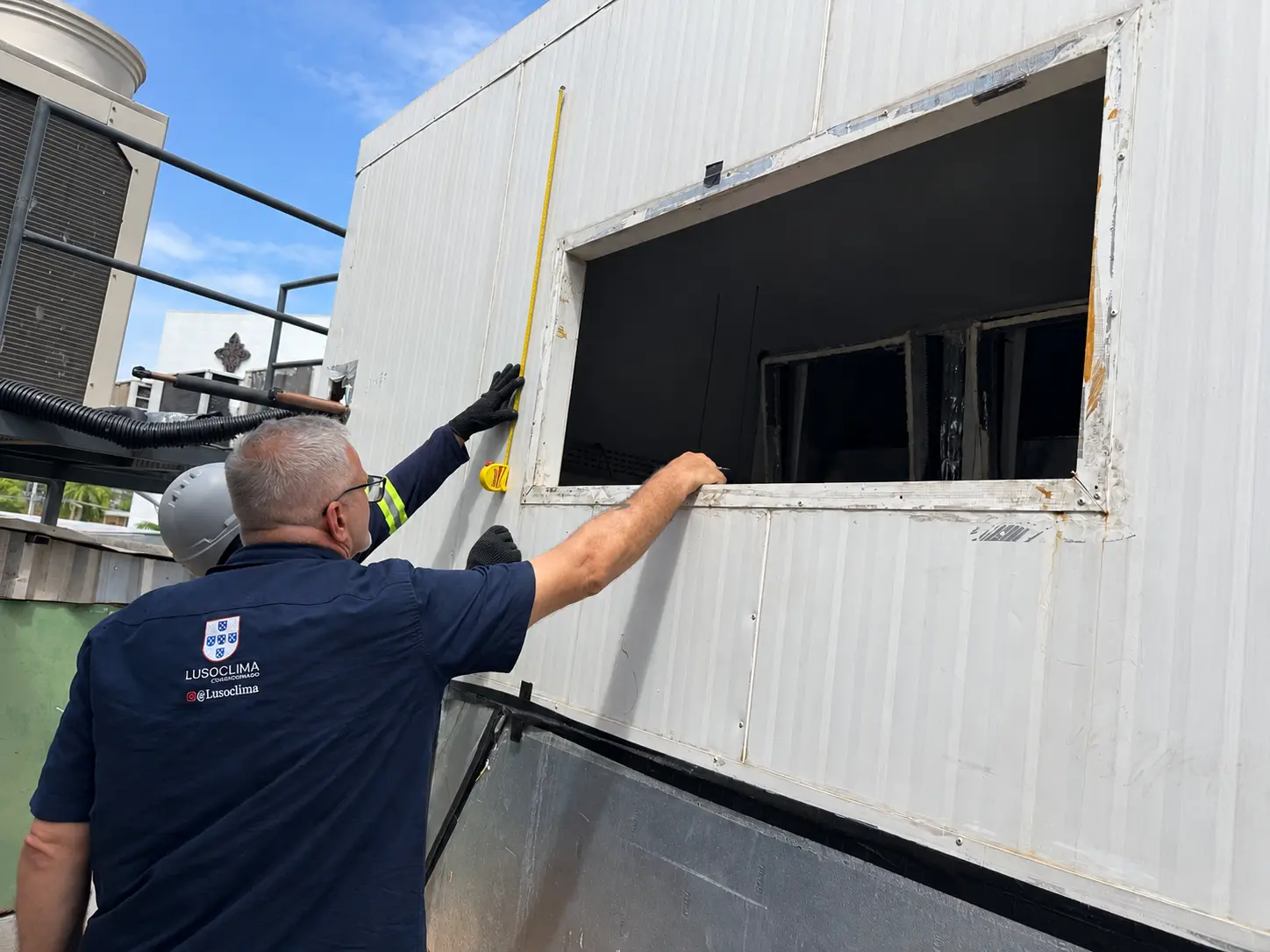 Profissional Lusoclima medindo abertura de unidade de climatização em cobertura